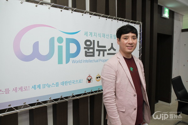 Professor Hee-Sung Lee from Dankook University Department of Culture and Arts poses in front of the photo wall at the foundation ceremony of WIP-News. 
