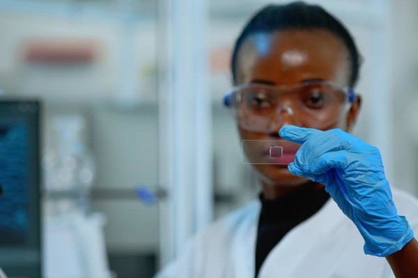 Black female scientist examines slide [Photo Provided = U.S. Chamber of Commerce]
